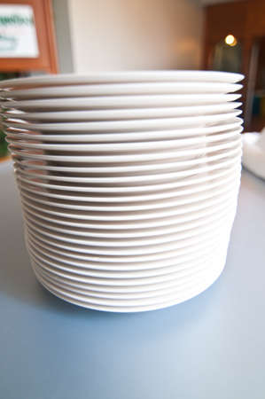 Stack of plates on dining tableの写真素材