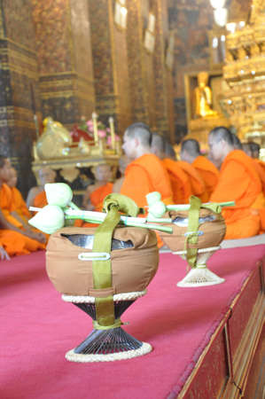 A new monk lights incense during a Buddhist ordination ceremony in Bangkok, Thailandのeditorial素材
