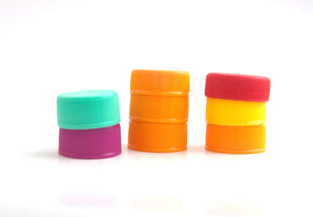 pile of multicolored used plastic bottle caps on white backgroundの写真素材