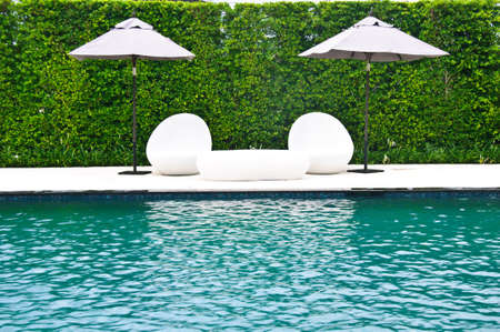 Luxury swimming pool with white fashion deckchairsの写真素材