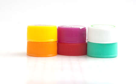 pile of multicolored used plastic bottle caps on white backgroundの写真素材