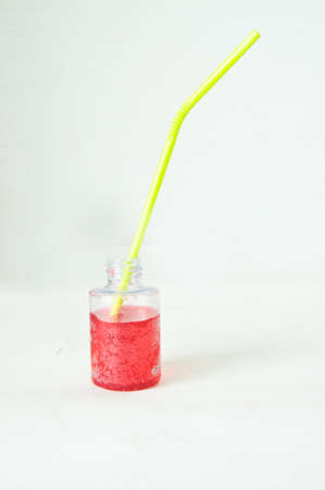 yellow drinking straws in red waterの写真素材