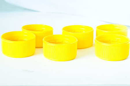 yellow plastic bottle screw caps used to seal plastic bottlesの写真素材