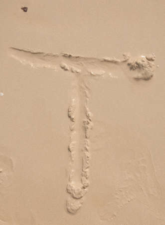 The alphabet written in sand on a beach - Tの写真素材