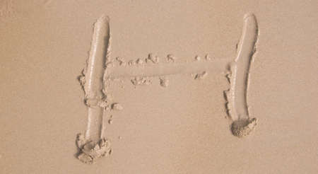 The alphabet written in sand on a beach - Hの写真素材