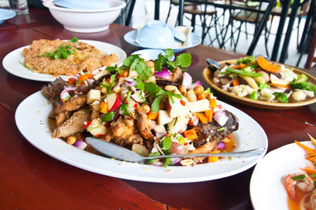 Herb salad with deep fried fish and lemongrass. Thai food.の写真素材