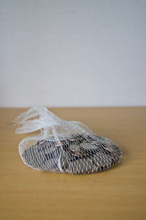 Thai coin in net bag on wood tableの写真素材