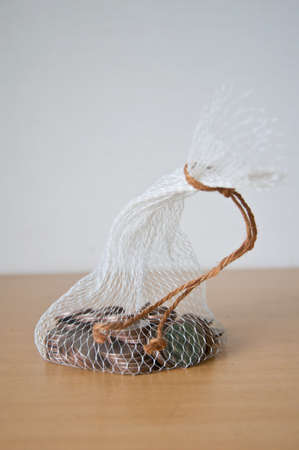 Thai coin in net bag on wood tableの写真素材