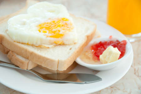 Fried eggs with hotdog Orange juice and toastsの写真素材