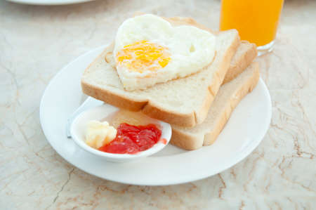 Breakfast - toasts, egg and strawberry jamの写真素材