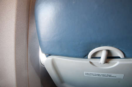 inside airplane seat, focusing with the warning label of "fasten seat belt"の写真素材