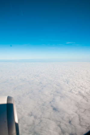 View from airplane window with blue sky and white cloudsの写真素材