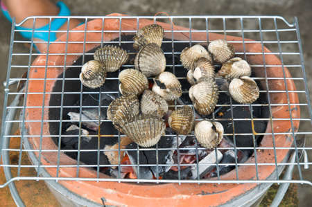Cockles on flaming grillの写真素材