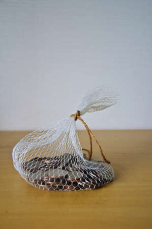 coin in net bag on wood tableの写真素材
