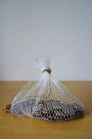 coin in net bag on wood tableの写真素材