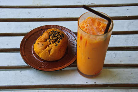 Refreshing cold frappe tea and bread on tableの写真素材