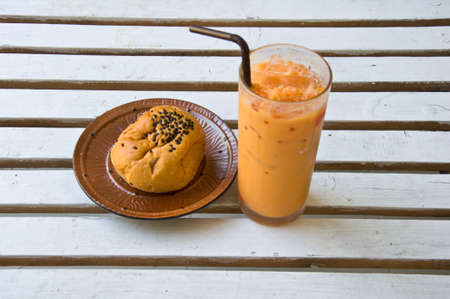 Refreshing cold frappe coffee and bread on tableの写真素材