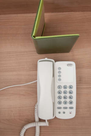 Telephone and notepad on wood tableの写真素材