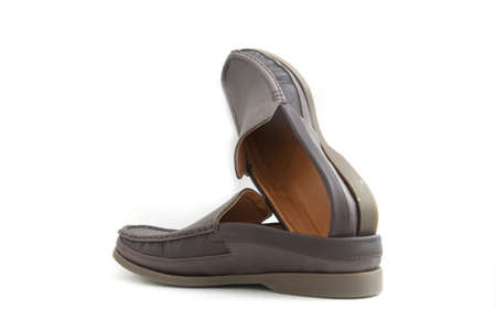 brown slip-on casual shoes over a white backgroundの写真素材