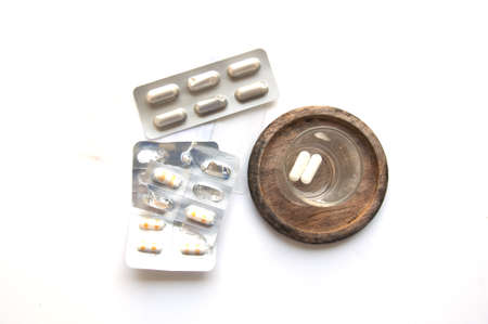 Capsule pill and glass of water on white backgroundの写真素材