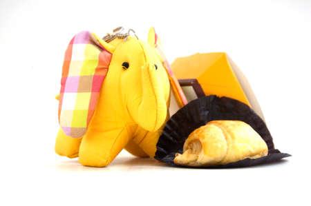 Yellow silk elephant toy and croissantの写真素材