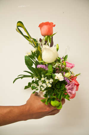 close up of man's hand giving bouquet of flowersの写真素材