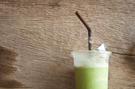 milk green tea smoothie in plastic cup wood backgroundの写真素材