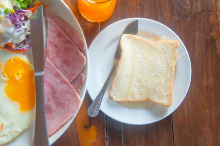 fried eggs with hotdog , bacon and toastsの写真素材