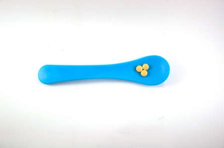 Plastic spoons with yellow pillsの写真素材