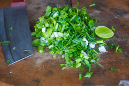 Chopped green onions on a cutting board and knifeの写真素材