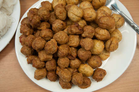fried meatballs in dish on wood tableの写真素材
