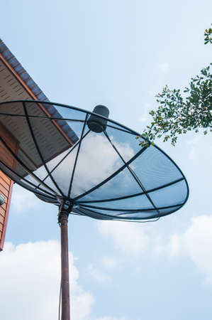 Black Satellite Dish on blue sky.の写真素材