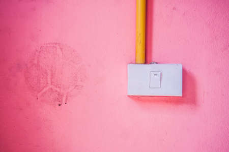 Old switch on the pink cement wallの写真素材