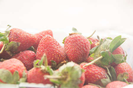 Fresh strawberries in plastic box on white backgroundの写真素材