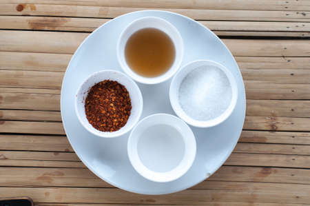 Thai seasoning container include cayenne pepper, sugar, fish sauce and chiliesの写真素材