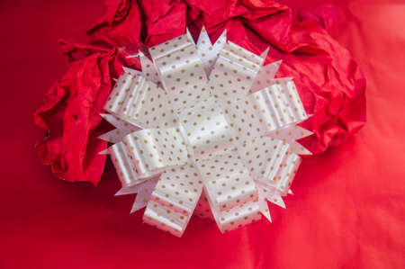 Classic white present bow on red paper