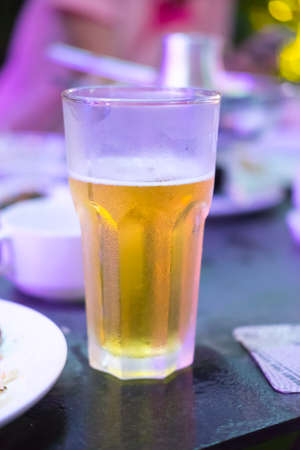 Yellow beer glass in a restaurantの写真素材