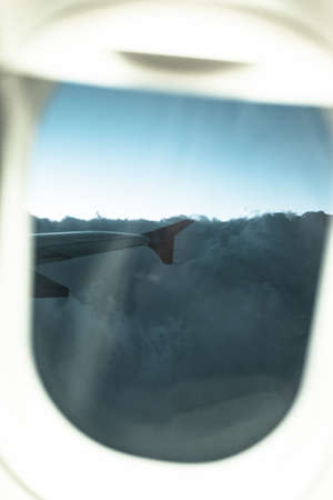 cloudy blue sky as seen through window of an aircraft