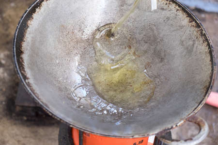 Pouring oil on panの写真素材