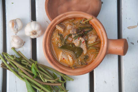 Morning glory in sour red curry ,Traditional Thai curry in bowl