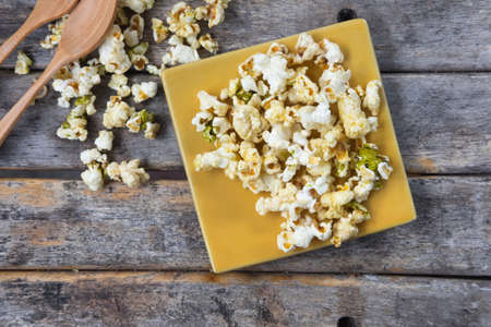 Salt and green tea popcorn on the wooden tableの写真素材