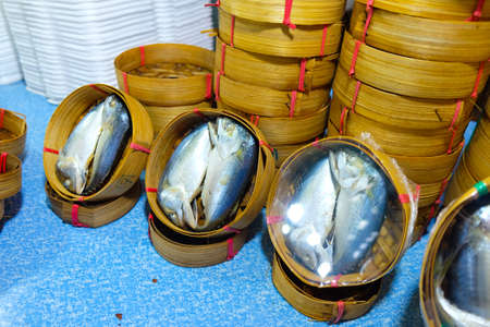 Thai gulf mackerel fish steamed on bamboo basket in different sizes for display at a fish market ; Thai people called this fish is Pla-tooの写真素材