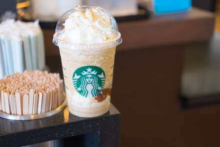 Samutprakarn, Thailand - May 6, 2016: Glass of Starbuck coffee ice cappuccino blended beverages served on wooden table at starbucks coffee shop inside Home Pro Village , Suvarnabhumishopping mallのeditorial素材