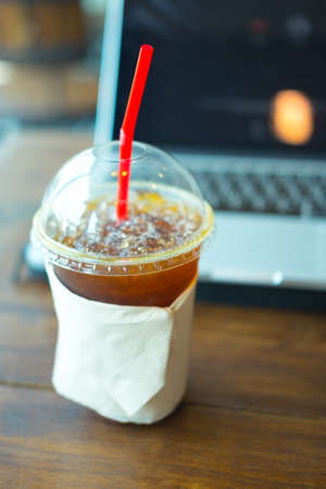 ice coffee americano with laptop notebook backgroundの写真素材