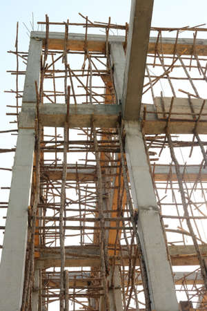 Timber beam formwork supported by row of scaffolding in construction site