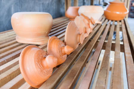 Thai Traditional Clay Pottery on wood shelves