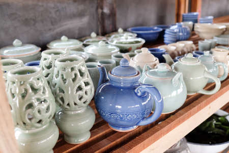 Thai traditional ceramic jar on wood shelvesの写真素材