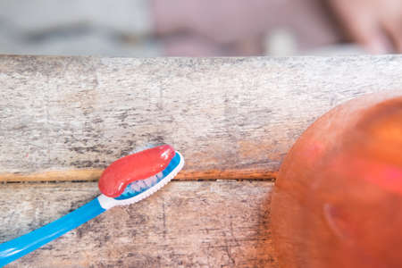 Red toothpaste being squeezed onto a toothbrushの写真素材