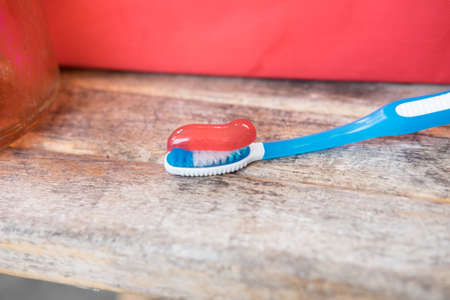 Red toothpaste being squeezed onto a toothbrushの写真素材