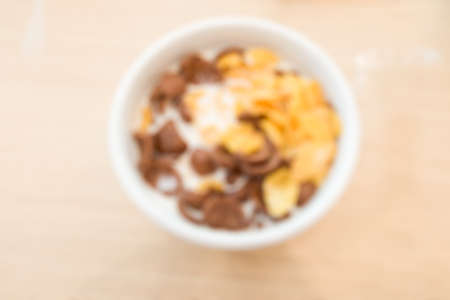 Blur of cornflakes with milk in a white bowl